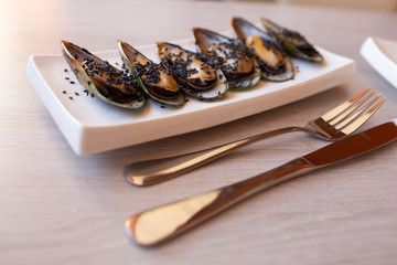 Shrimp mussels and squid on frying pan close up with garlic and cutlery cook