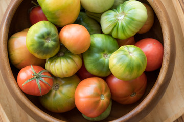 Red and green tomatoes on a wooden background. Tomato harvest
