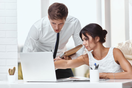 Caucasion man and woman working together in a modern office