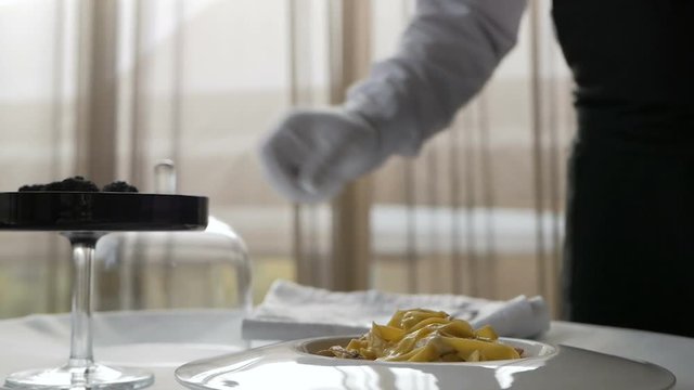 Chef grates truffle on pasta in Italian restaurant