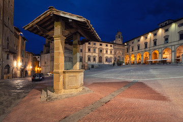 Arezzo, Italy. Old well located on Piazza Grande square at dusk