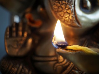 Close up flame in front of a ganesha deity