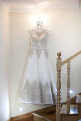 Cream bride hang on the lamp against the wall next to the stairs in the hotel