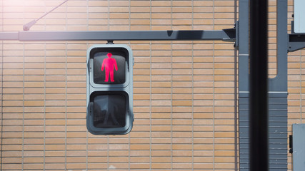 Traffic light for people to walk and stop crossing the street with red bricks background.