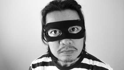 Robber man with black mask thinking about plotting for robbery, Thief robbery concept