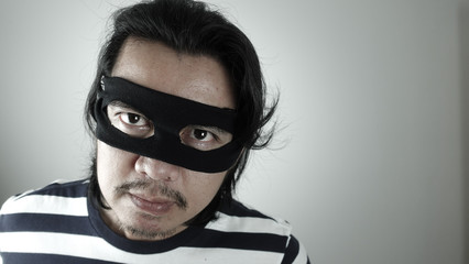 Robber man with black mask thinking about plotting for robbery, Thief robbery concept