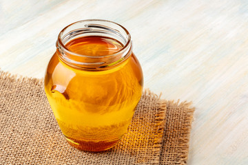 A photo of a jar of honey on a rustic background with copy space