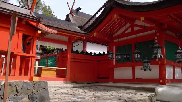 beautiful female traveler walking in the temple through the passageway full of lanterns