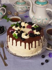 Delicious cream cake on the table with a tablecloth and tea in beautiful set