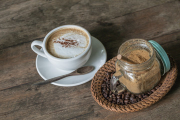 A cup of coffee in the wooden table.