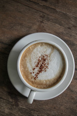 A cup of coffee in the wooden table.