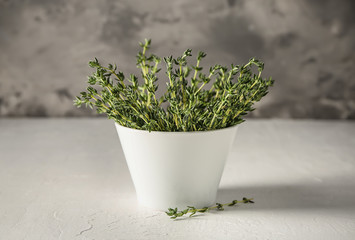 Bowl with fresh thyme on white table