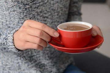 Woman holding cup of aromatic coffee, closeup