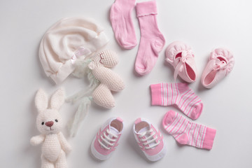 Baby clothes, shoes and toys on white background