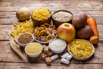 Foods high in carbohydrate on rustic wooden background.