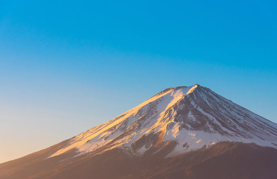 Close-up of Mount Fuji view with Lake Kawaguchi and clear blue sky background in Kawaguchiko, Japan.Peak of Fuji mountain cover with snow and shading with golden sunlight in the morning.