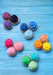 Fototapeta na wymiar Tasty colorful cupcakes on wooden background