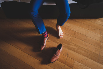 Man in suit getting his socks on