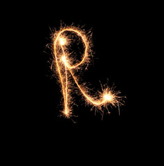 Sparklers forming letter R on dark background