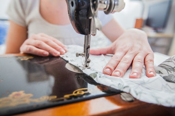 Female Tailor Using Retro Sewing Machine At Home