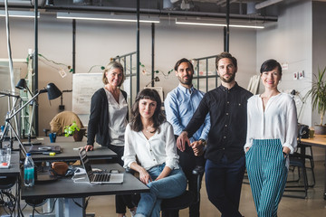 Portrait of colleagues at desk in office