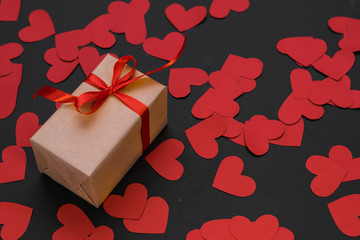 the gift box is wrapped in a red ribbon, a scroll wrapped in a red ribbon, and paper hearts around,...