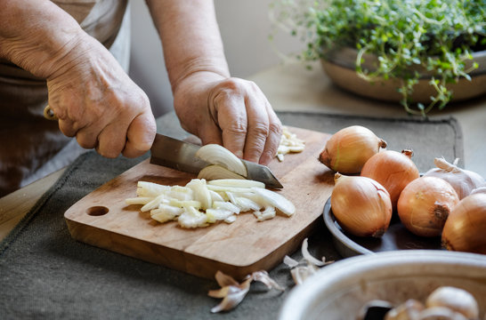 Cook slicing onions on a cutting board