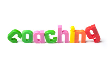 closeup of colorful plastic letters on white background - Coaching