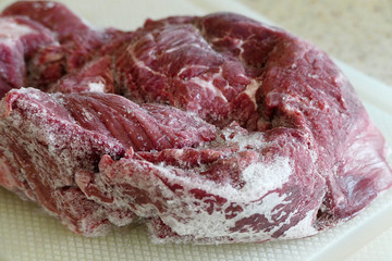 frozen beef in refrigerator, left to thaw,