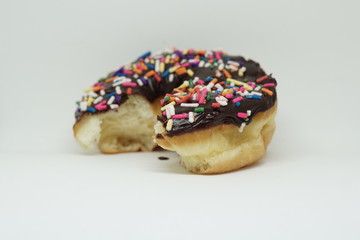 bitten chocolate doughnut on an isolated white background