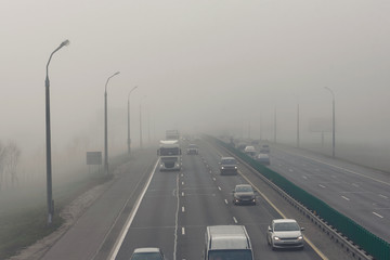 .Dense fog and poor visibility on the road. Dangerous driving situations. View on highway traffic...