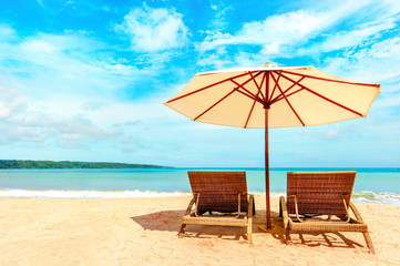 Empty beach chairs and umbrella on a sandy tropical beach. Paradise Island for holidays and relaxation.