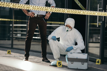 cropped view of male detective looking at work of criminilogist