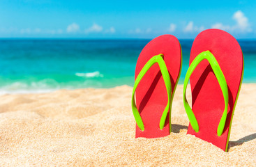 Fototapeta na wymiar Beautiful beach. Beach sandals on the sandy coast. Summer holiday and vacation concept. Tropical beach.