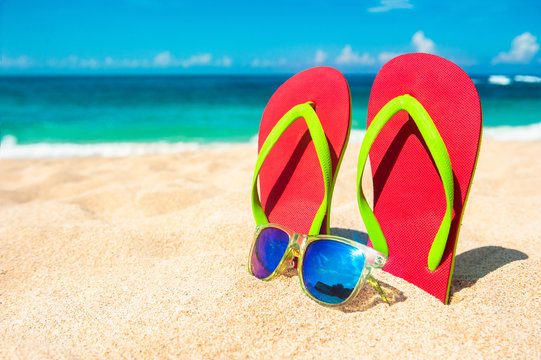 Beautiful beach. Beach sandals on the sandy coast. Summer holiday and vacation concept. Tropical beach.