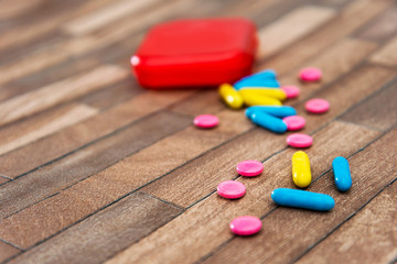 Medicine box and bottle on colorful pills