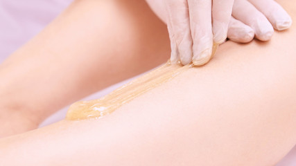 Obraz na płótnie Canvas Depilation spa procedure. Woman hair remove waxing. Epilation sugaring. Legs foot