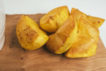 Baked potatoes placed on wooden board