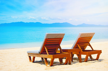 Fototapeta na wymiar Beautiful beach. Chairs on the sandy beach near the sea. Summer holiday and vacation concept.