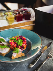 Beetroot salad vinaigrette, sandwiches with fish, alcoholic drinks and black paper card of menu