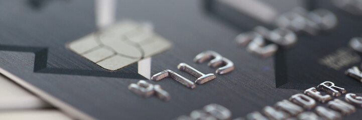 Embossed chipped credit card lying on silver keyboard - obrazy, fototapety, plakaty