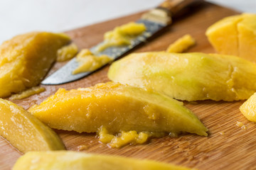 Mango with Slices Cut with Knife on Wooden Surface Board.