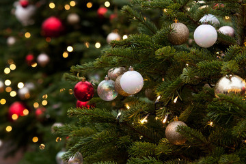Obraz na płótnie Canvas furry fir-tree decorated with bright Christmas balls and a garland of light bulbs