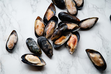 Top view with frozen mussels on white marble background