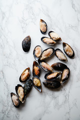 Top view with frozen mussels on white marble background