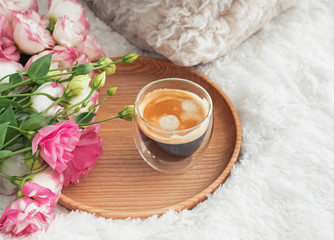 Coffee and flowers on the bed close-up.