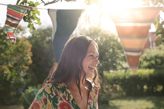 Smiling brunette woman standing in backyard
