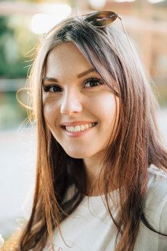 Close-up portrait of smiling young woman with brown hair