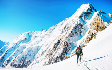Fototapeta na wymiar Climber reaches the top of mountain peak. Climbing and mountaineering sport.