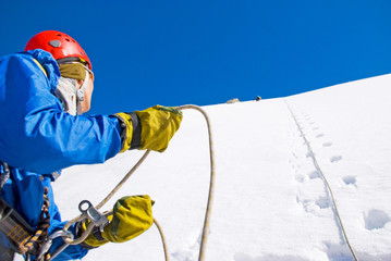 Climber with backpacks reaches the summit of mountain peak. Success, freedom and happiness,...